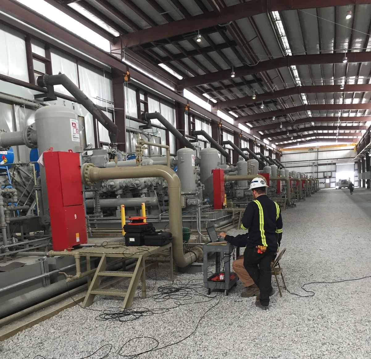 A man working in an industrial setting with pipes.